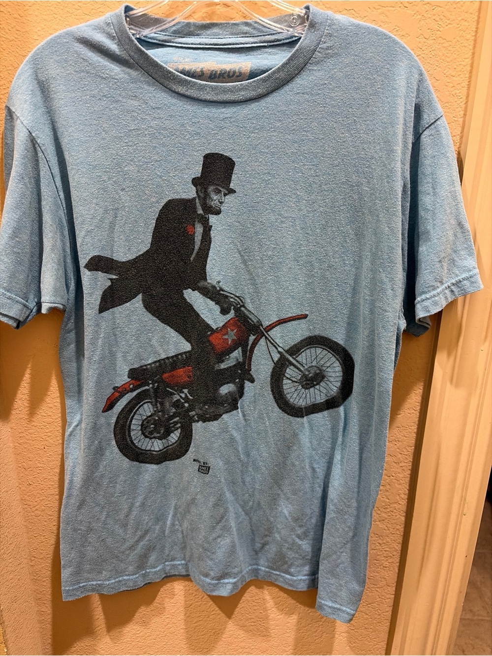 Ames Bros Men's Light Blue Graphic Tee with Abe Lincoln Dirt Bike